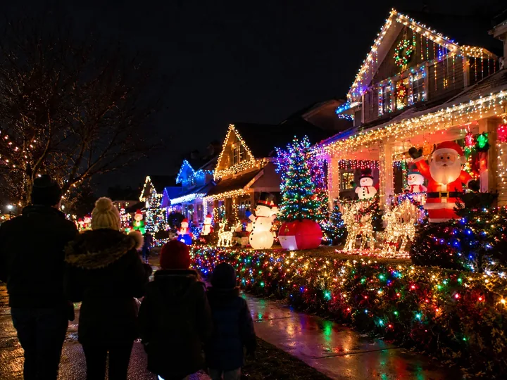 Houses covered in holiday lights at night