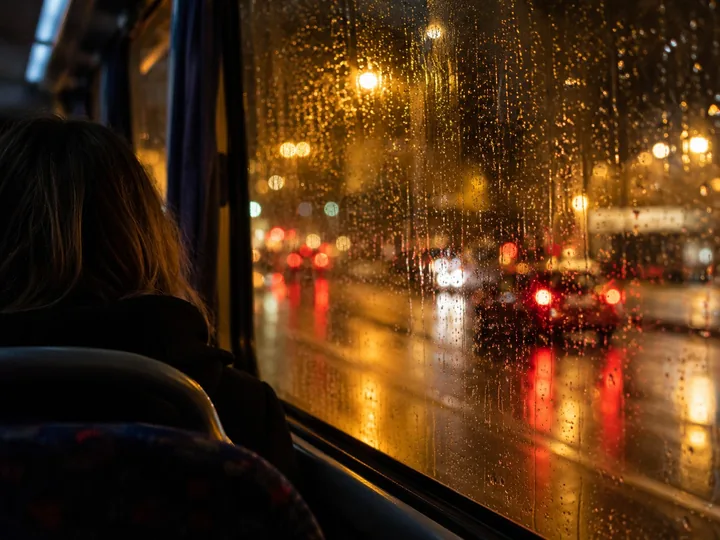 Blurred city lights through a bus window at night