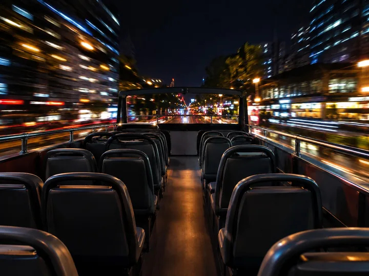 The open upper deck of a sightseeing bus at night