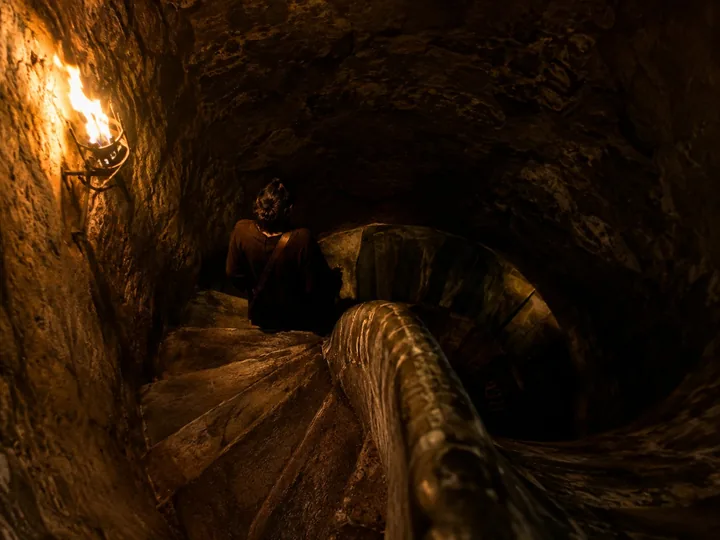 A spiral stone staircase descending into darkness