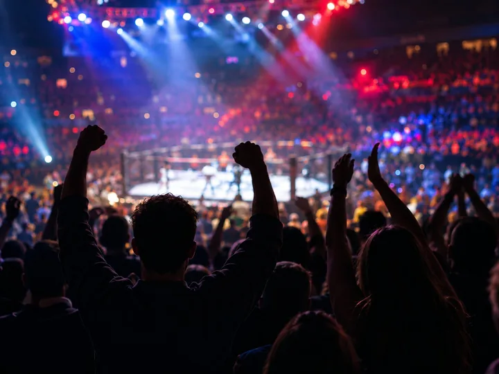A cheering arena crowd under colored lights