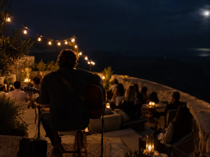 A musician playing on a rooftop terrace at night