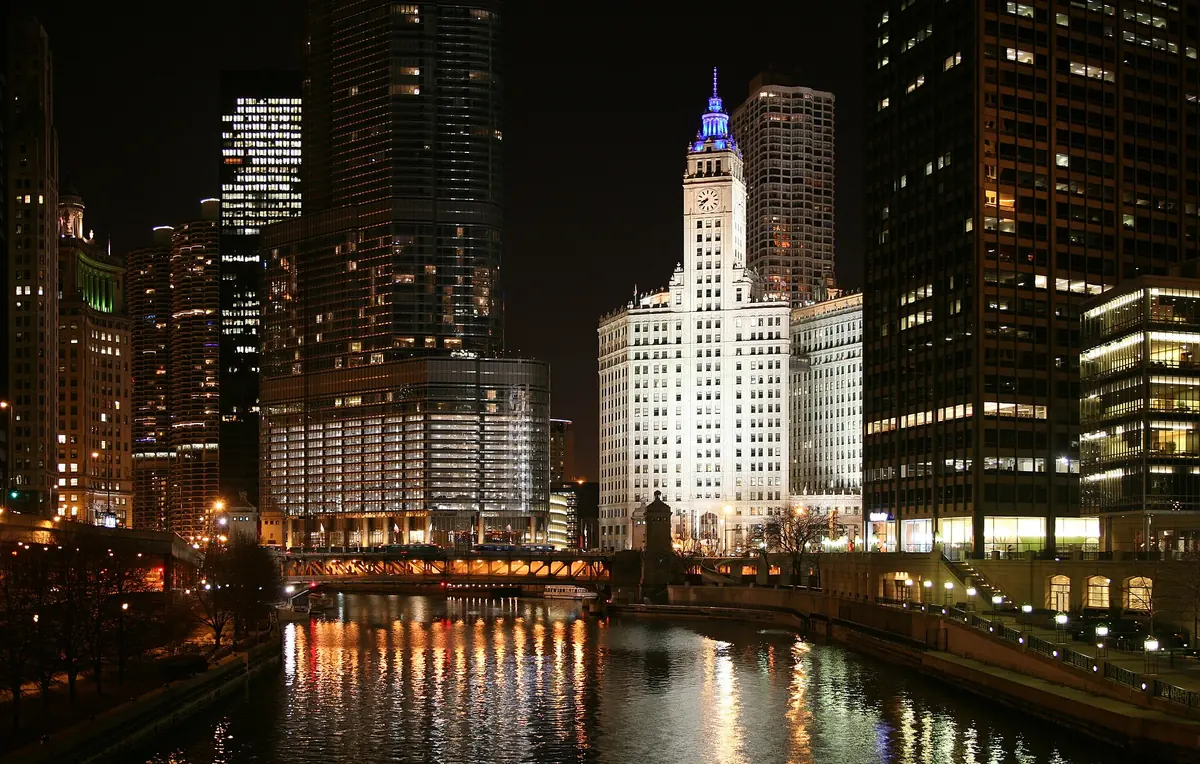 The Wrigley Building and towers along the Chicago River at night