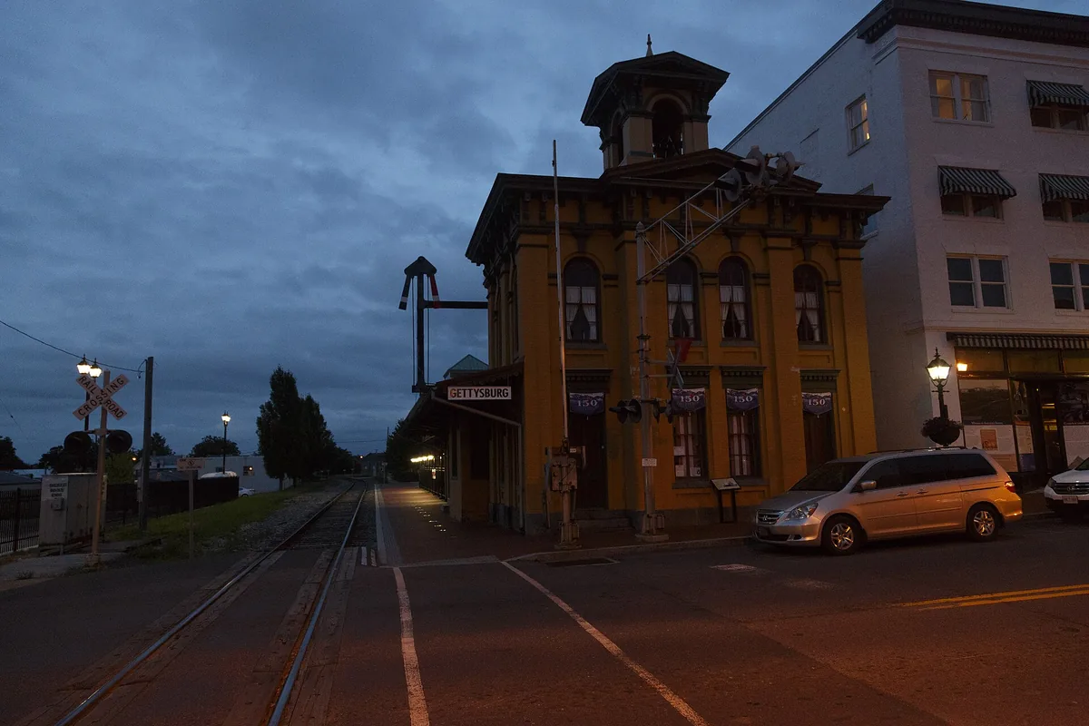 The Lincoln railroad station in Gettysburg at dusk, with the tracks crossing the street