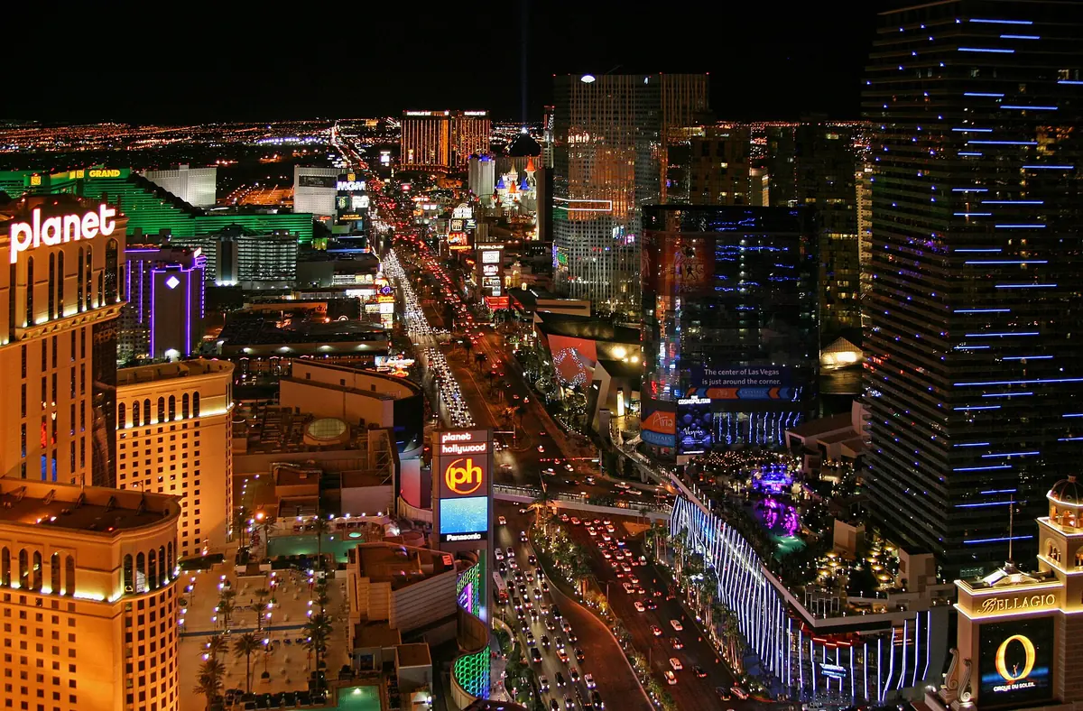 The Las Vegas Strip at night seen from above, with traffic trails and casino lights