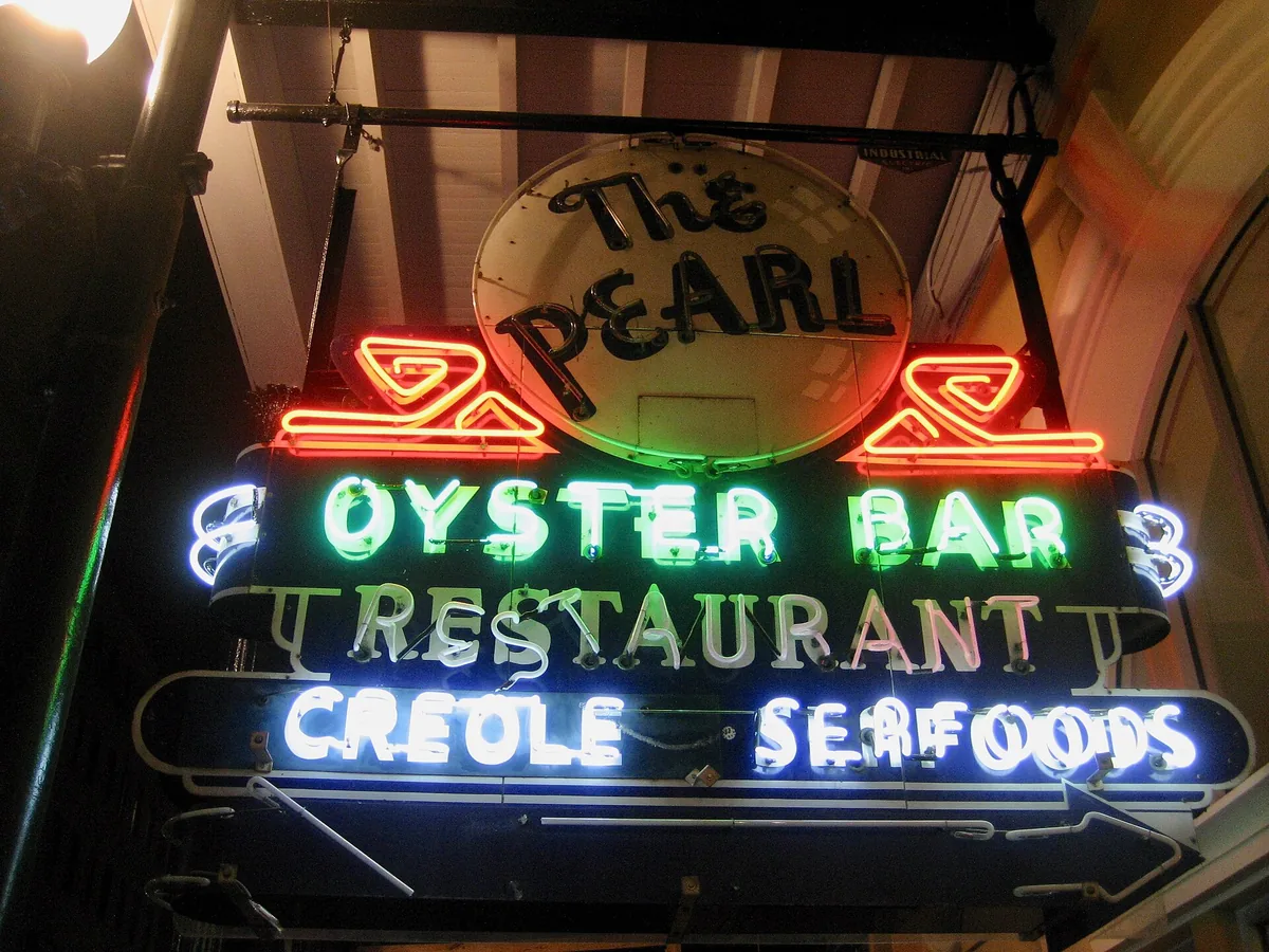 The neon sign of The Pearl oyster bar and restaurant in New Orleans at night