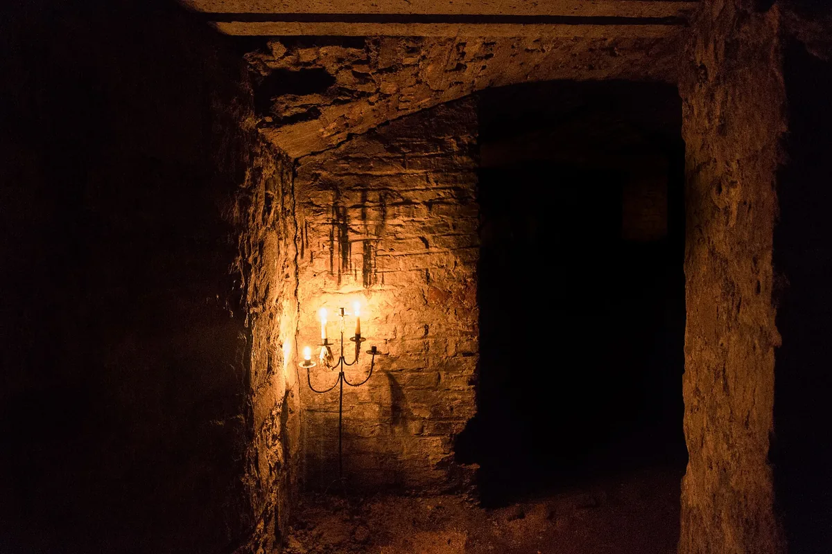A candle-lit stone passage in Edinburgh's underground vaults