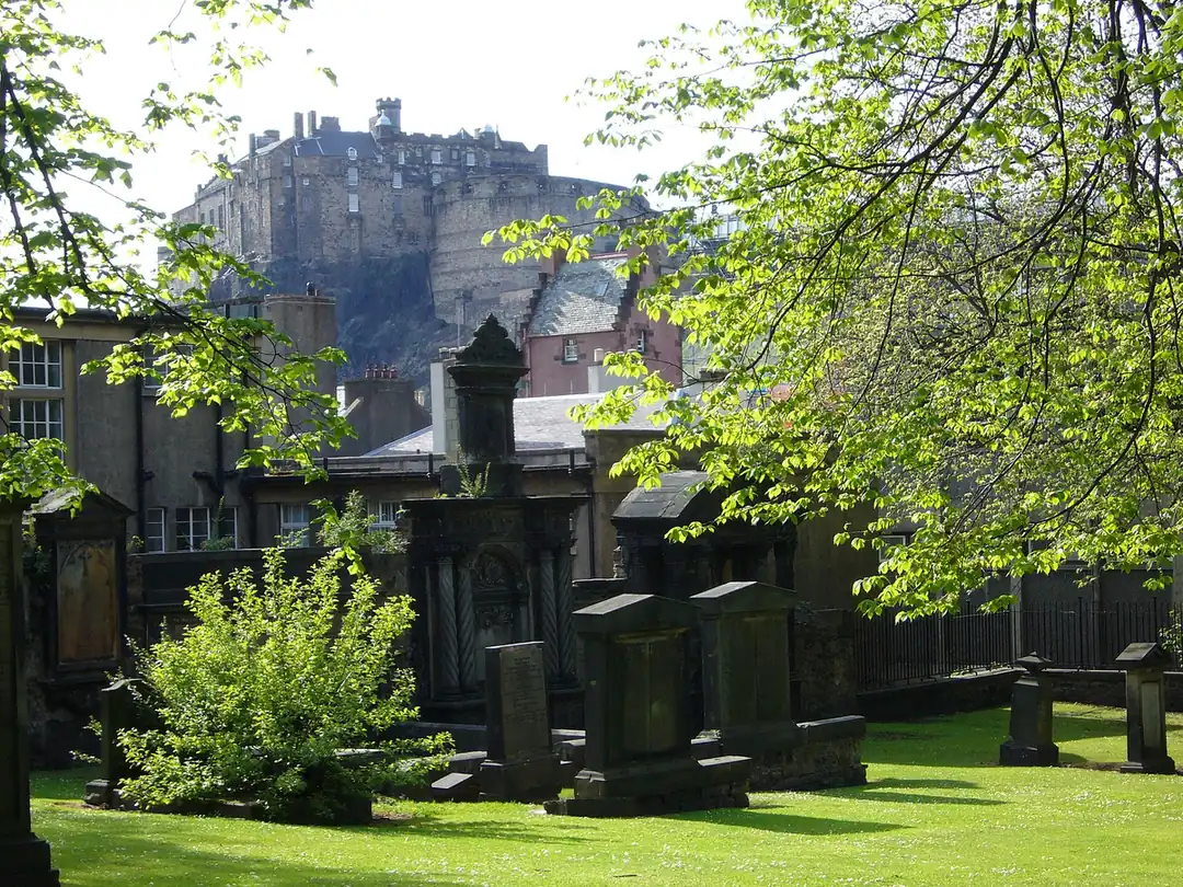 Greyfriars Kirkyard in Edinburgh by day, with the castle above the trees